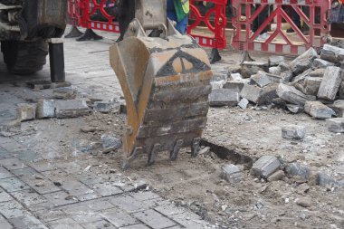 Kazıcının kaldırım ve enkazı kaldırdığı bir şantiye..