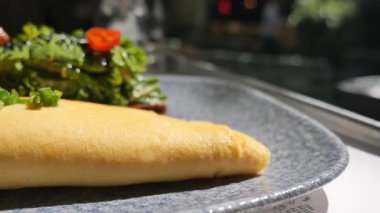 Taze bitki ve biberli yumuşak bir omlet tabakta servis edilir..