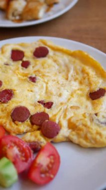 Taze domates ve sebzelerle servis edilen lezzetli omletin tadını çıkarın..