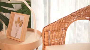 Şık bir dekor, bir sandalyenin yanındaki ahşap çerçevede kurumuş çiçekleri gösteriyor..