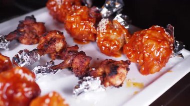 Sos ve susamlı baharatlı tavuk kanatlarının tadını çıkar..