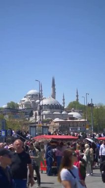 Kalabalık güneşli gökyüzünün altındaki tarihi bir caminin yakınında toplanırken hareketli bir gün başlıyor..