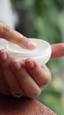 Dışarıdaki küçük bir konteynırdan el kremi sürüyorum..