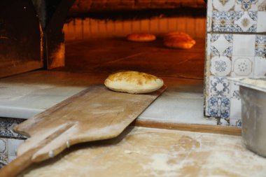 Yerel bir fırının ahşap fırınında taze ekmek pişiriliyor..