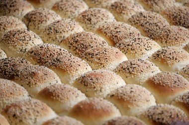 Sıcak bir mutfakta piştikten sonra soğuyan altın susamlı börekler..