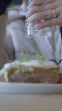 Bir insan, yerel bir kafede güzel bir tabağa baharat katar..