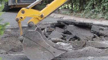 İnşaat ekipmanları yerleşim alanındaki hasarlı bir yolu onarıyor..