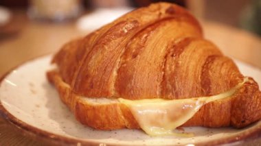 Bir kafede sıcak, yapışkan peynirle dolu lezzetli bir kruvasan deneyin..