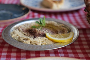 Limonla süslenmiş humus kareli masa örtüsüne konur..
