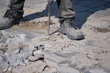 İnşaat işçisi inşaat alanında beton kırmak için bir araç kullanır..