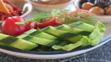 Çıtır salatalıklar ve renkli sebzeler bir tabakta güzelce sıralanır..