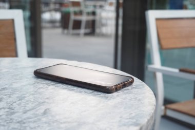 Kafe ortamında bir masada dinlenen akıllı telefon. Akıllı telefon kavramını kaybettim ,