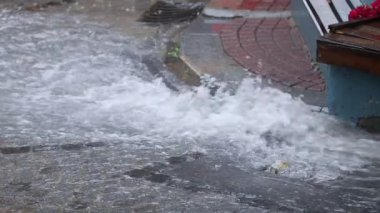 Şiddetli yağmur şehir sokaklarında su birikintisine ve sele yol açar..