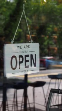 Kafe vitrininde asılı bir tabela müşterileri hoş karşıladığını gösterir..