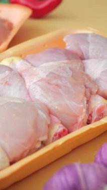 Mutfak tezgahında çiğ tavuk butlarını renkli sebzelerle hazırlıyorum..