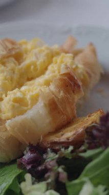 Çırpılmış yumurta, kruvasan ve taze sebzeli leziz bir yemeğin tadını çıkarın..