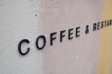 Duvara asılmış bir kahve ve restoran tabelasının yakın görüntüsü..