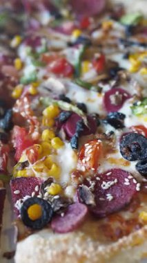 Zeytin, mısır ve bol peynirli bu lezzetli pizzanın tadını çıkar..