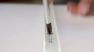 Becerikli bir el, bir tornavidayla vidayı sıkılaştırır..