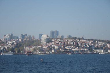 Canlı bir şehir, sahil boyunca kayık ve binaların yer aldığı ufuk çizgisi..