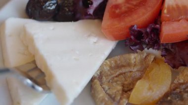 İçinde domates, zeytin ve peynir bulunan renkli bir salatada yemek..