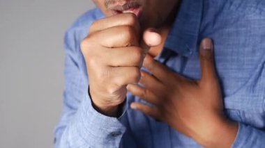 Bir adam öksürüyor ve göğsünü sıkıca tutuyor. Bu da olası bir sıkıntıyı işaret ediyor..