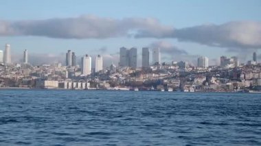İstanbul 'un muhteşem silueti. Suyun üzerinde binalar ve bulutlar..