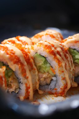 Taze malzemelerle dolu suşi ruloları baharatlı soslarla süslenir..