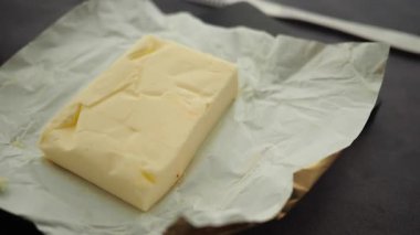 Bir kalıp tereyağı kağıda sarılıp pişirilmeye hazır olarak gösteriliyor..