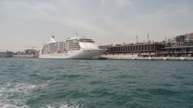 Güneşli bir günde büyük bir yolcu gemisi limana yanaşır..