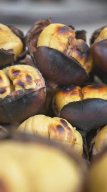 Taze kavrulmuş kestaneler hareketli bir pazarda sergilenir.