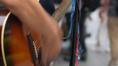 Sokak sanatçısı canlı gitar melodileriyle kalabalıkları eğlendiriyor.