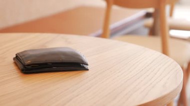 Cüzdan kafede ahşap bir masada dinleniyor, cüzdan konsepti kayıp. ,