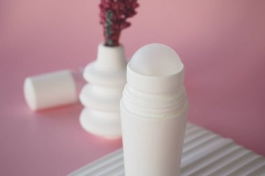 Yumuşak Pembe Arkaplan Yüzeyinde Minimalist Deodorant Şişesi.