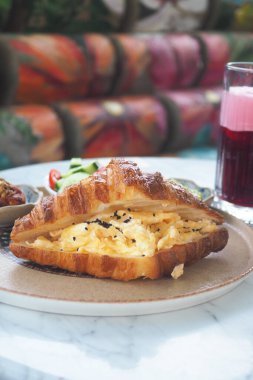 Çırpılmış yumurta ve meyve suyuyla servis edilen lezzetli kruvasan..