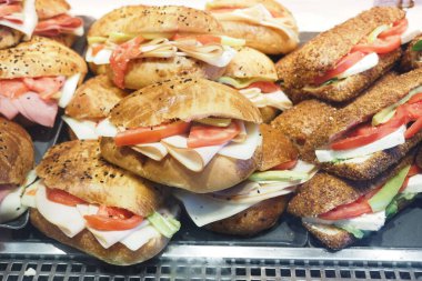 Çeşitli malzemelerle taze hazırlanmış sandviçler baştan çıkarıcı bir şekilde sergileniyor..