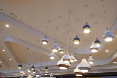 Şık bir kafenin tavanında asılı şık kolye ışıkları.