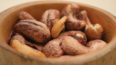 Ahşap bir kasede kavrulmuş kaju fıstığının zengin dokusunu keşfediyorum..