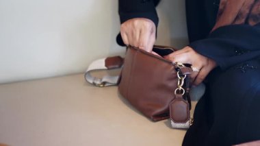 Bir kadın eşyalarını sakin bir ortamda çantasından topladı..