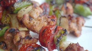 Canlı sebzelerle servis edilen ızgara tavuk şişleri ve dumanlı bir tat..