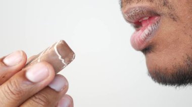 Bireysel olarak bir çikolata parçasının tadını çıkarıyor, keyifli bir anın altını çiziyor..