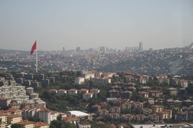 Konut binaları ve bir bayrağın yer aldığı İstanbulların ufuk çizgisi.