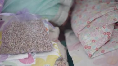 Renkli çiçeklerin yanına konmuş kokulu lavanta kesesi sergilenmekte..