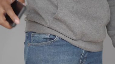 Telefonunu cebine koyan kişi