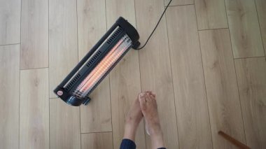 Kışın, içeride ısıtıcı ile ayaklarını ısıtır..