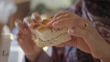 Yüzüklü bir insan taze malzemeli lezzetli bir sandviç tutar..