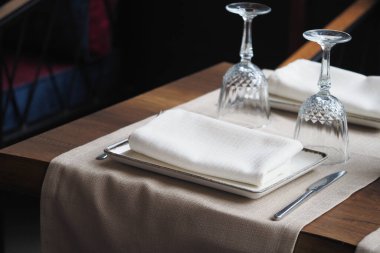 Sofra takımı ve yemek için ince cam eşyalar içeren parlak dekore edilmiş bir masa..