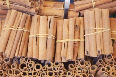 Kalabalık bir pazarda sergilenen bağlanmış tarçın çubukları.