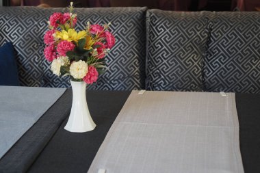 Canlı bir vazo ve şık tekstil içeren bir masa..