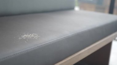 Toz belirgin bir şekilde çağdaş bir ortamda şık bir kafe koltuğuna yerleşiyor..